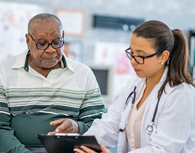 Doctor showing senior patient a tablet