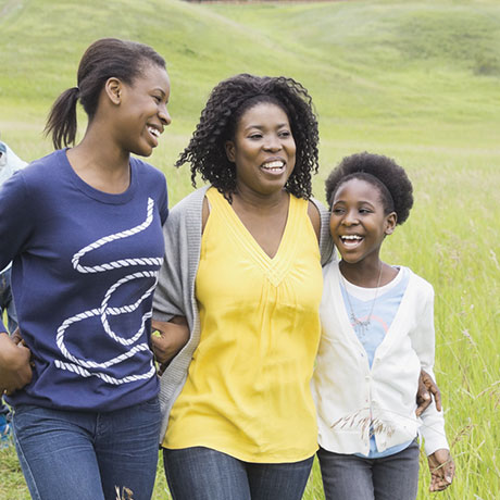 Mother smiling and walking with daughters smiling