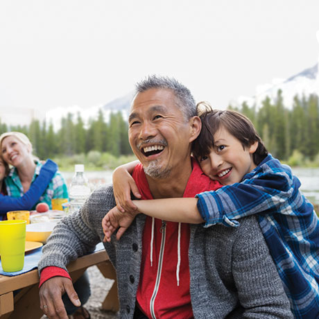 father and son sitting on picnic bench smiling